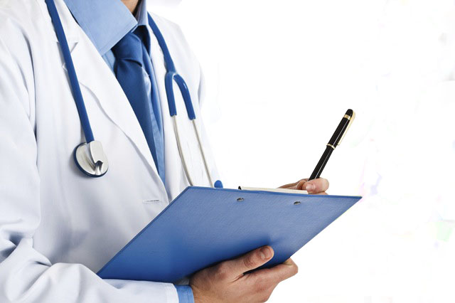 A doctor taking notes on his clipboard for the patient's careplan'